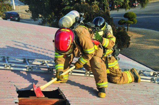 Firefighters breaking into a roof